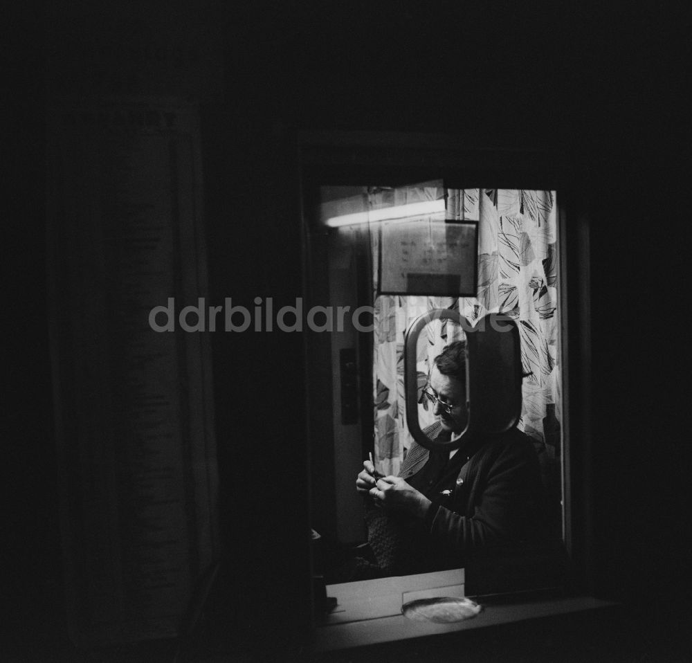DDR-Fotoarchiv: Berlin - Lichtenberg - Alte Frau sitzt in einem Fahrkartenhäuschen und strickt in Berlin - Lichtenberg