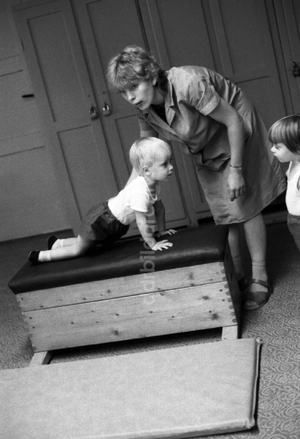DDR-Fotoarchiv: Berlin - Betreuung einer Kindergartengruppe bei der Sporterziehung in einem Turnraum in Berlin in der DDR