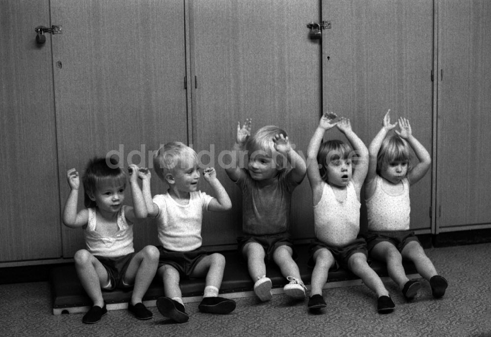 DDR-Fotoarchiv: Berlin - Betreuung einer Kindergartengruppe bei der Sporterziehung in einem Turnraum in Berlin auf dem Gebiet der ehemaligen DDR, Deutsche Demokratische Republik