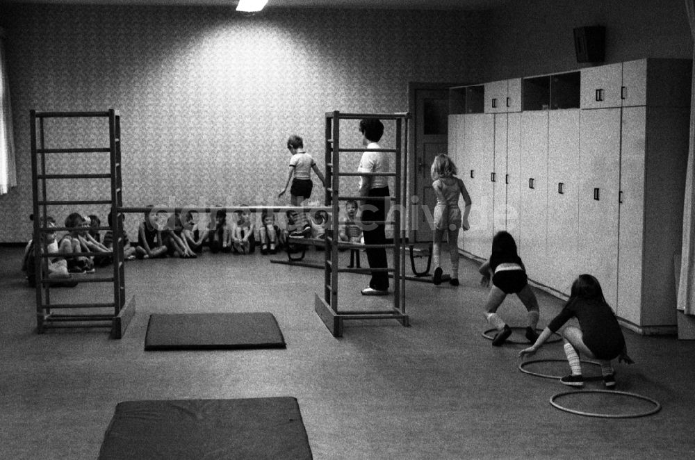 Berlin: Betreuung einer Kindergartengruppe bei der Sporterziehung in einem Turnraum in Berlin auf dem Gebiet der ehemaligen DDR, Deutsche Demokratische Republik