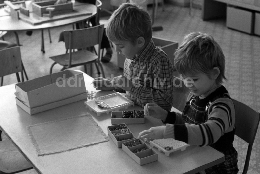 DDR-Fotoarchiv: Berlin - Betreuung einer Kindergartengruppe beim Spiel mit Holzbausteinen in Berlin, der ehemaligen Hauptstadt der DDR, Deutsche Demokratische Republik