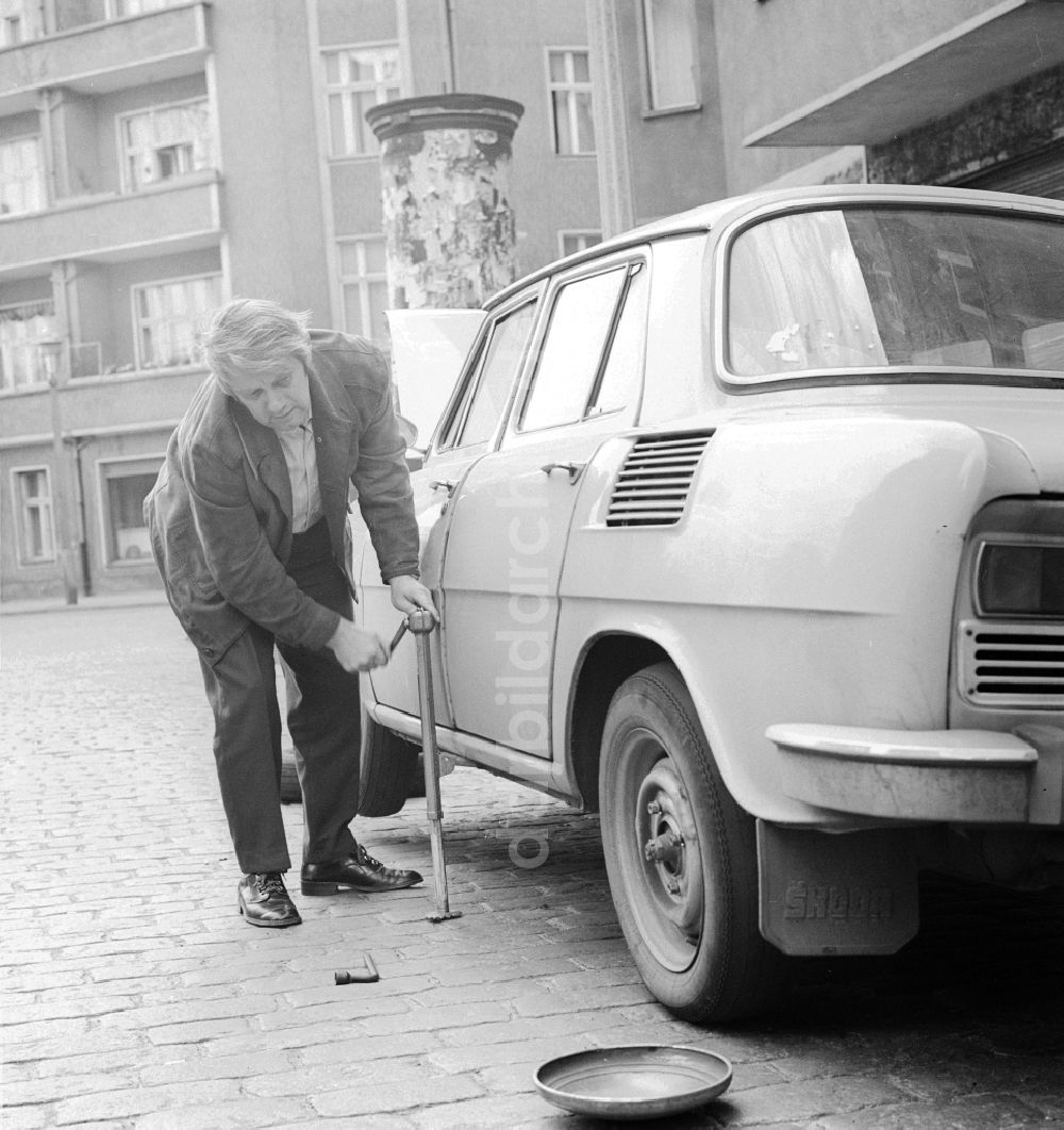 Berlin: Der Schauspieler Peter Borgelt (1927-1994) repariert auf der Straße sein Auto in Berlin, der ehemaligen Hauptstadt der DDR, Deutsche Demokratische Republik