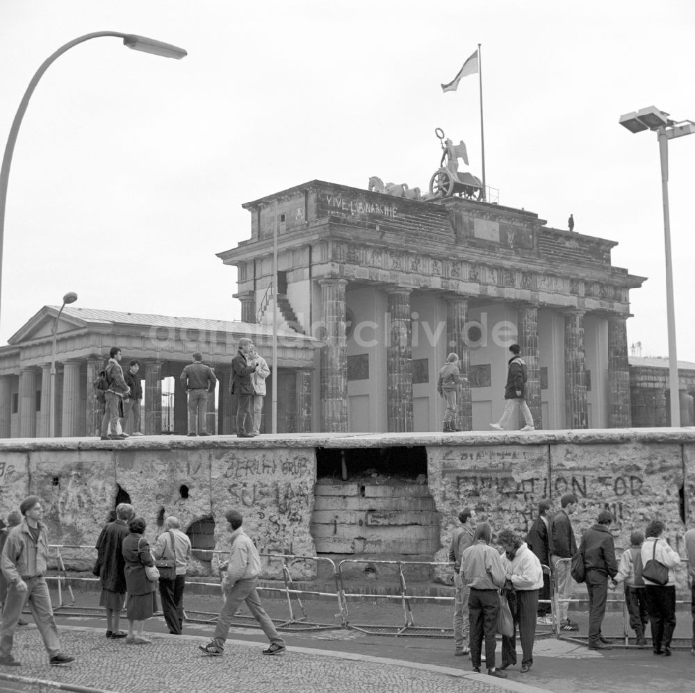 Berlin: Durch Mauerspechte gezeichnete Mauerreste vor dem Brandenburger Tor in Berlin