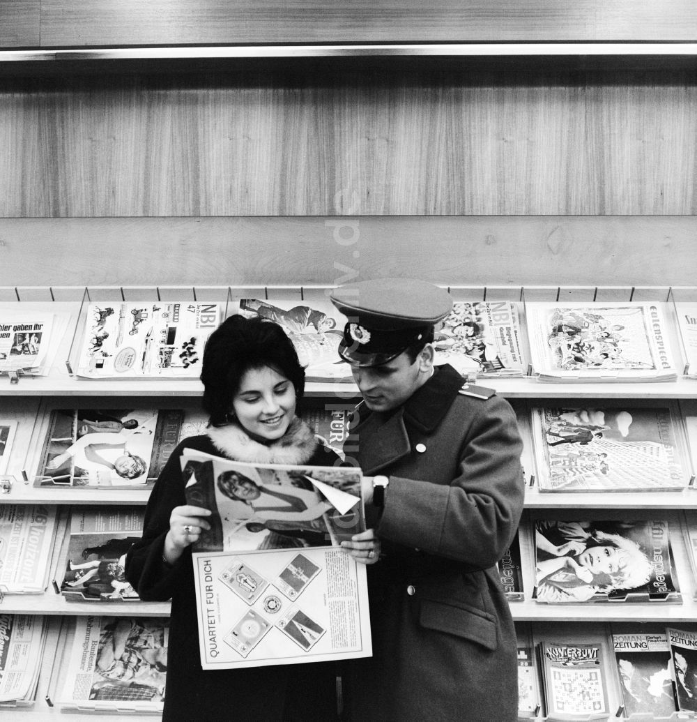 DDR-Fotoarchiv: Berlin - Ein junges verliebtes Paar in einem Zeitungsladen in Berlin, der ehemaligen Hauptstadt der DDR, Deutsche Demokratische Republik
