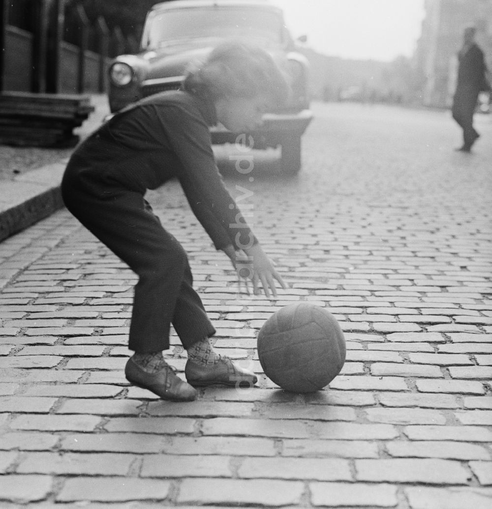 DDR-Fotoarchiv: Berlin - Ein Kind spielt mit einem Ball auf der Straße in Berlin