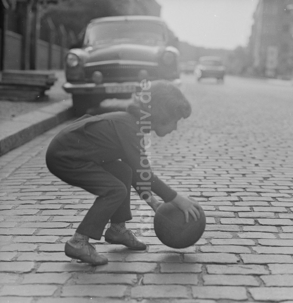 Berlin: Ein Kind spielt mit einem Ball auf der Straße in Berlin