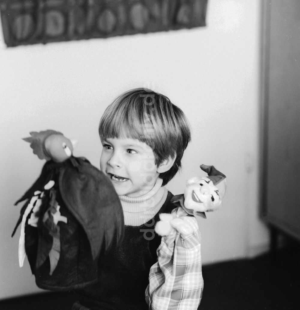 Berlin: Ein Kind spielt mit Handpuppen in Berlin, der ehemaligen Hauptstadt der DDR, Deutsche Demokratische Republik