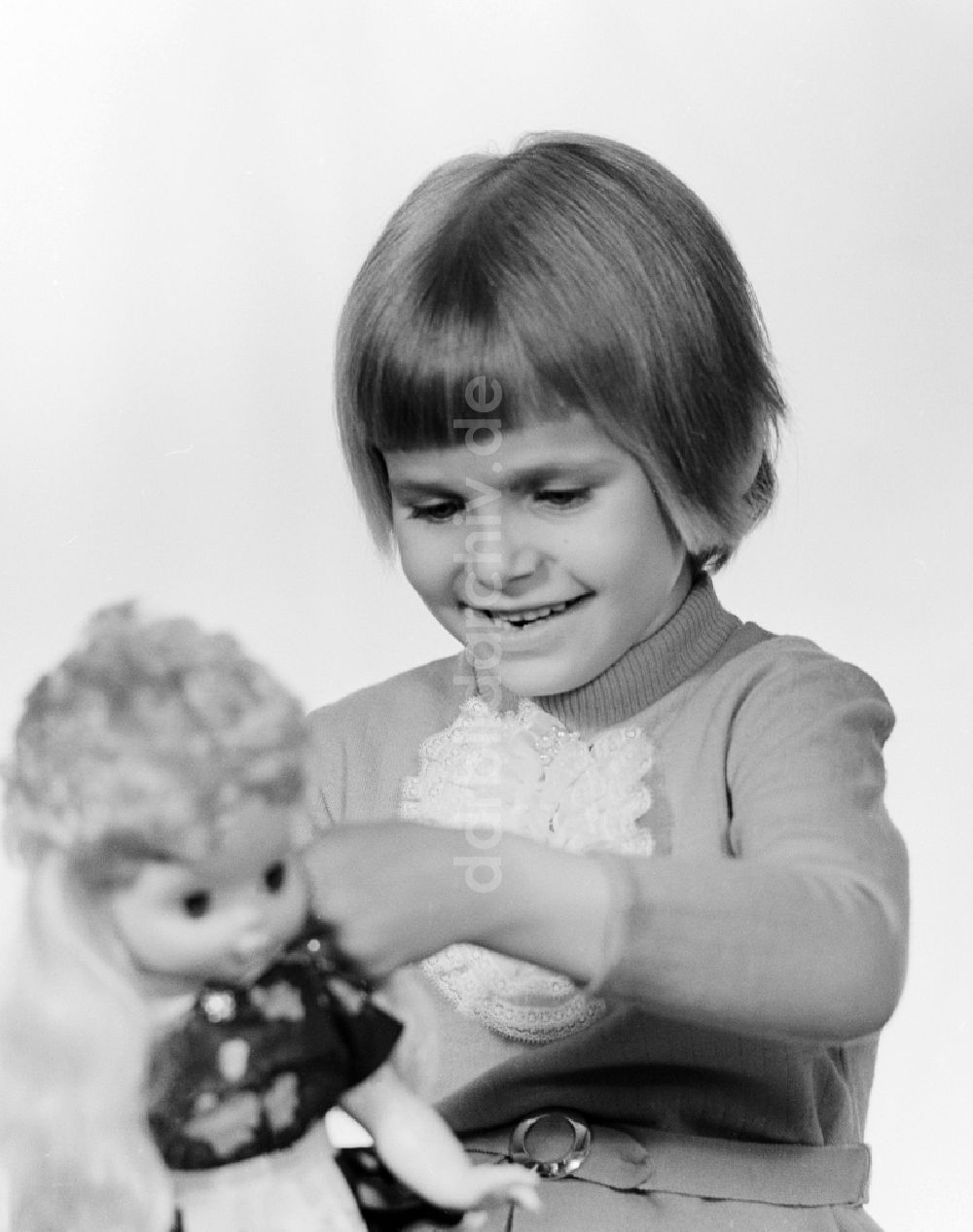 Berlin: Ein kleines Kind spielt mit einer Puppe in Berlin, der ehemaligen Hauptstadt der DDR, Deutsche Demokratische Republik