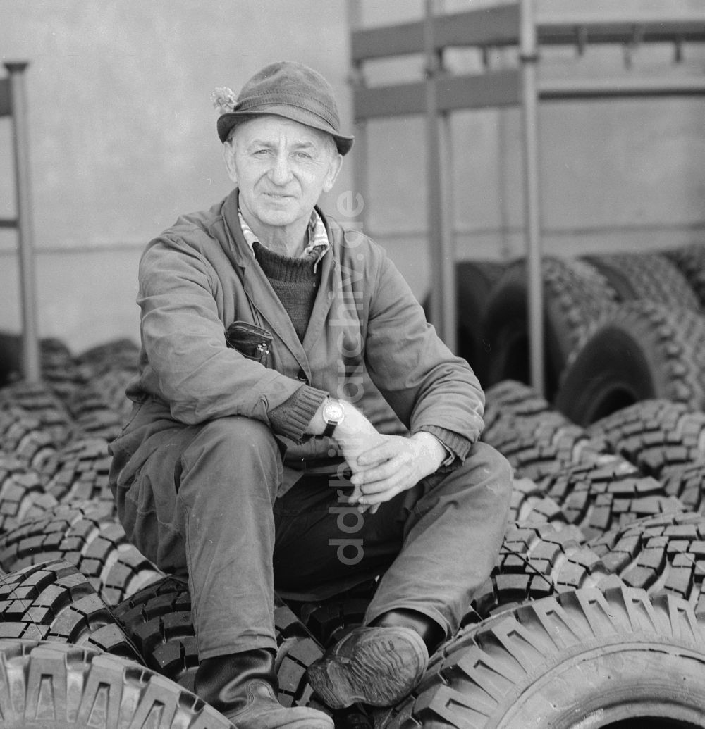 DDR-Bildarchiv: Berlin - Ein älterer Mann mit Hut sitzt auf Reifen in Berlin