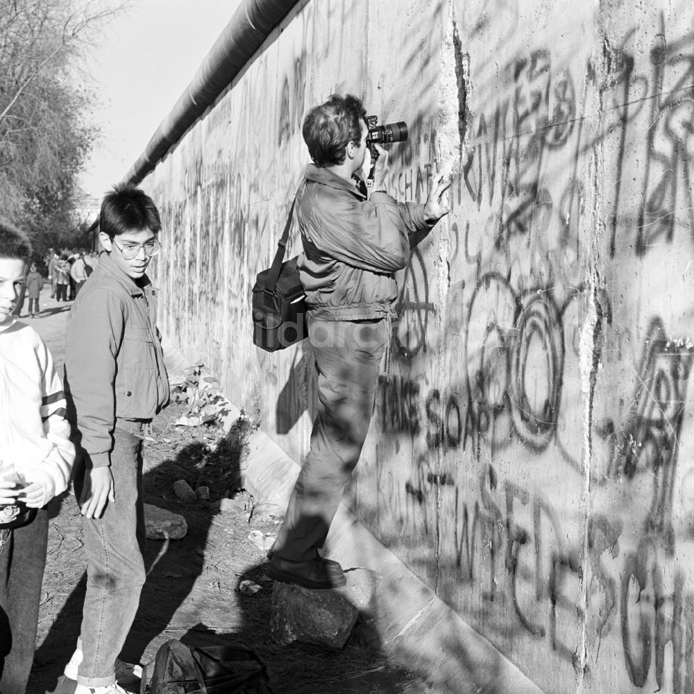 DDR-Fotoarchiv: Berlin - Mitte - Ein Mann fotografiert durch einen Spalt in der Berliner Mauer in Berlin