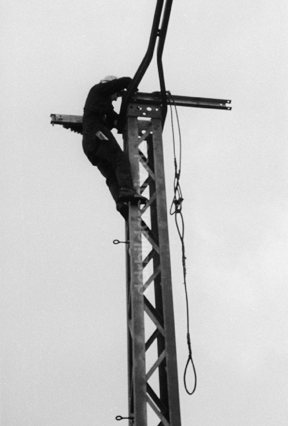 DDR-Fotoarchiv: Seddiner See - Ein Mitarbeiter der Deutschen Reichsbahn montiert an einen Fahrleitungsmasten am Bahnhof Seddin die Oberleitung in Seddiner See in Brandenburg in der DDR