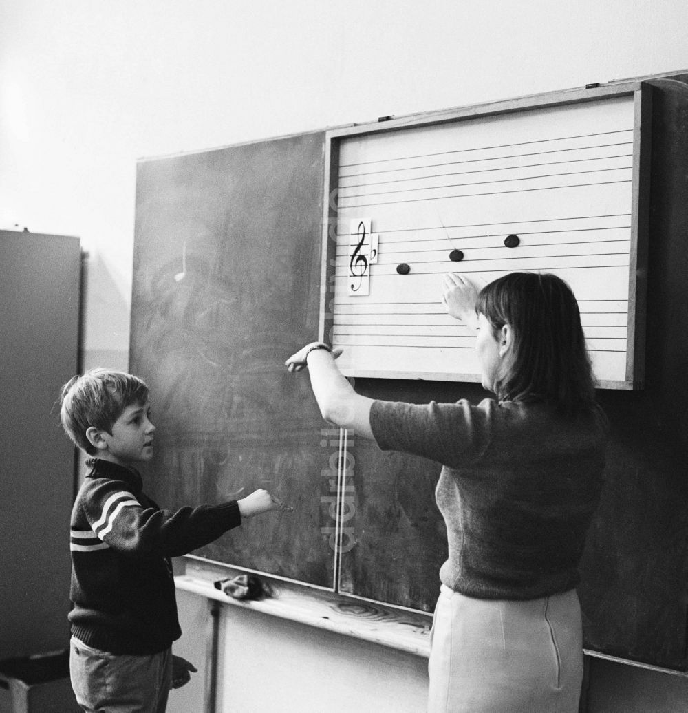 Berlin: Ein Schüler steht an der Tafel und die Musiklehrerin erklärt die Tonleiter in Berlin