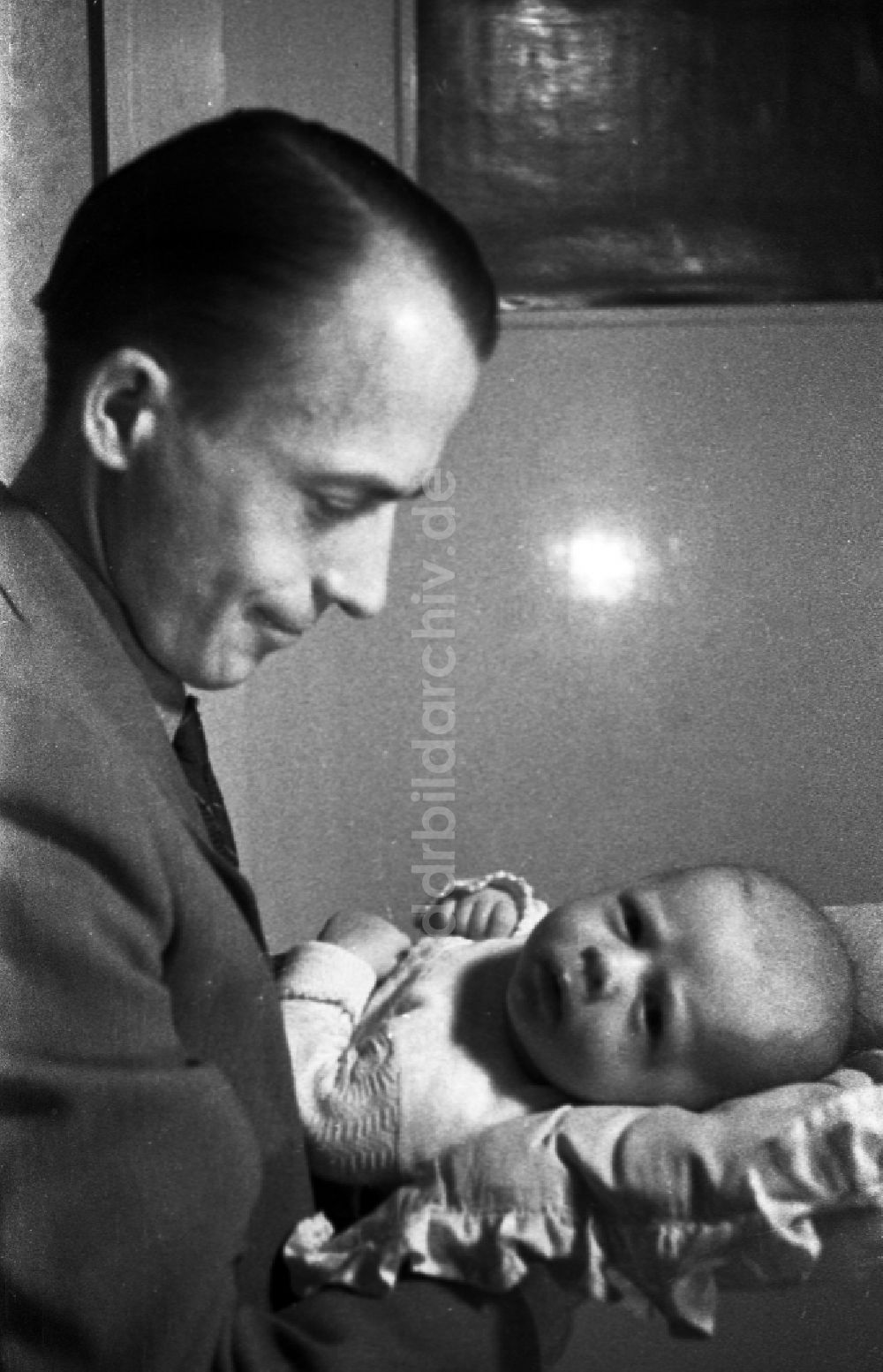 DDR-Fotoarchiv: Merseburg - Ein Vater hält stolz sein Baby auf dem Arm in Merseburg im Bundesland Sachsen-Anhalt auf dem Gebiet der ehemaligen DDR, Deutsche Demokratische Republik