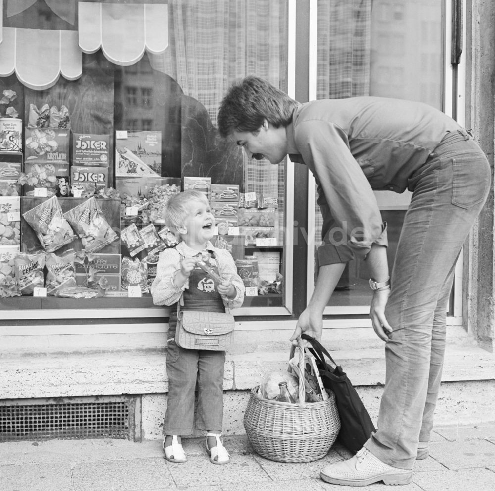 DDR-Fotoarchiv: Berlin - Ein Vater steht mit seinem Kind vor einem KONSUM - Lebensmittelgeschäft in Berlin, der ehemaligen Hauptstadt der DDR, Deutsche Demokratische Republik
