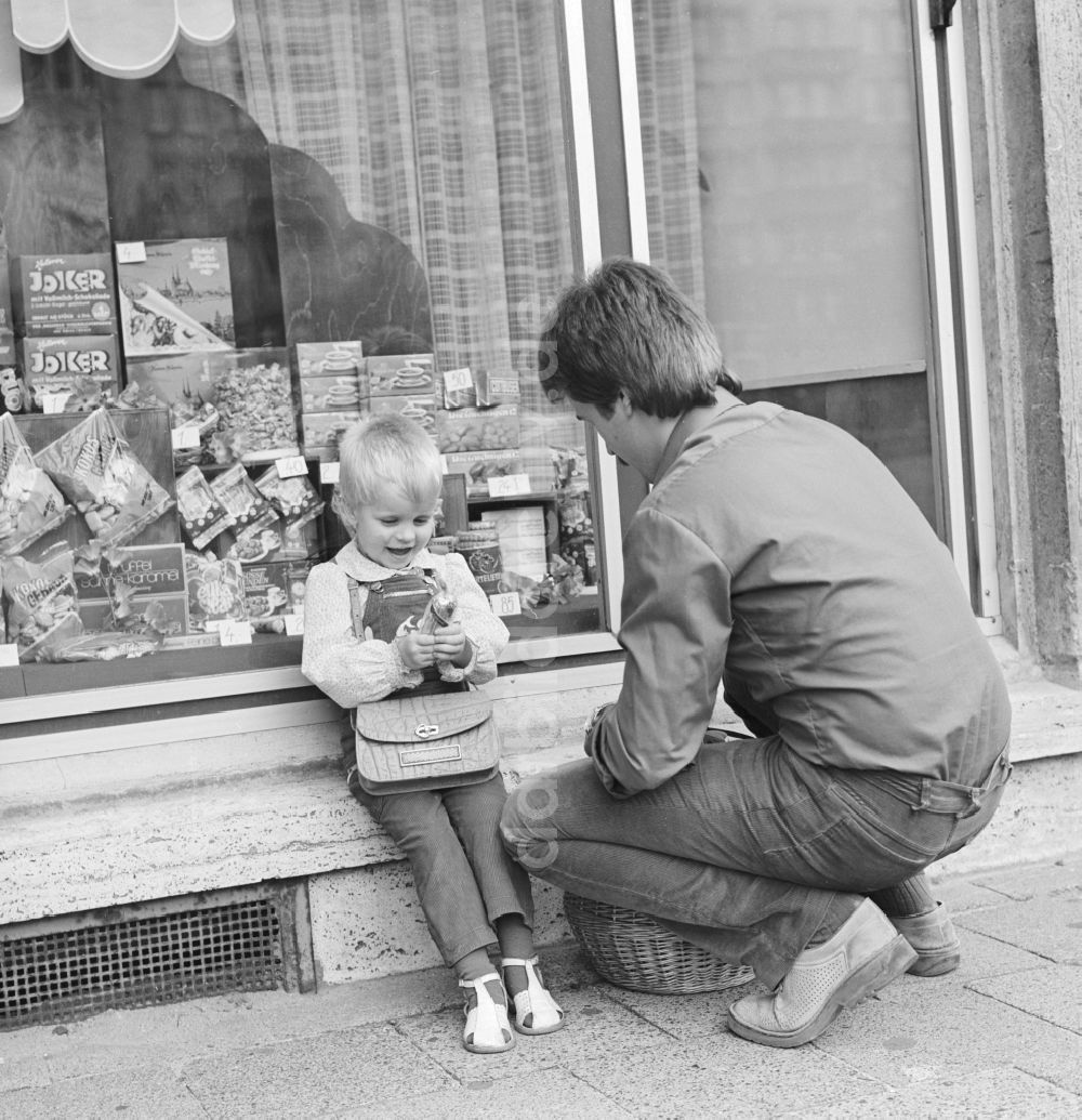 Berlin: Ein Vater steht mit seinem Kind vor einem KONSUM - Lebensmittelgeschäft in Berlin, der ehemaligen Hauptstadt der DDR, Deutsche Demokratische Republik