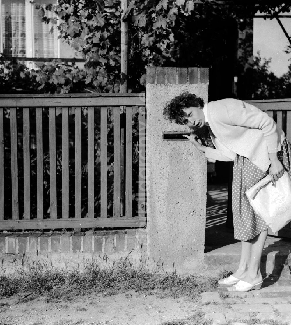 DDR-Fotoarchiv: Arnstadt - Eine Frau schaut erwartungsvoll in ihren Briefkasten am Haus in Arnstadt in Thüringen in der DDR