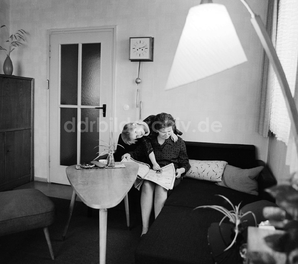 DDR-Bildarchiv: Berlin - Eine Frau sitzt auf dem Sofa und liest eine Zeitung in Berlin, der ehemaligen Hauptstadt der DDR, Deutsche Demokratische Republik