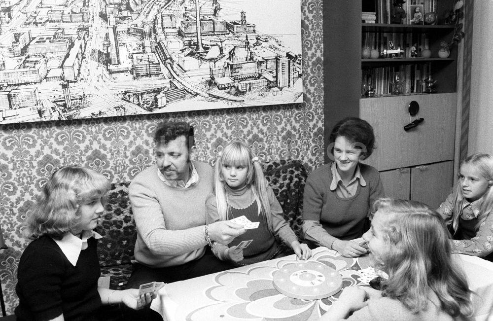 Berlin: Eine junge Familie beim Karten spielen im Wohnzimmer in Berlin