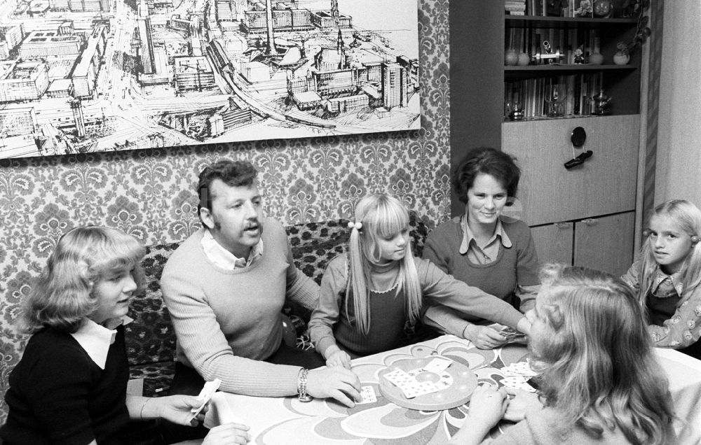 DDR-Bildarchiv: Berlin - Eine junge Familie beim Karten spielen im Wohnzimmer in Berlin