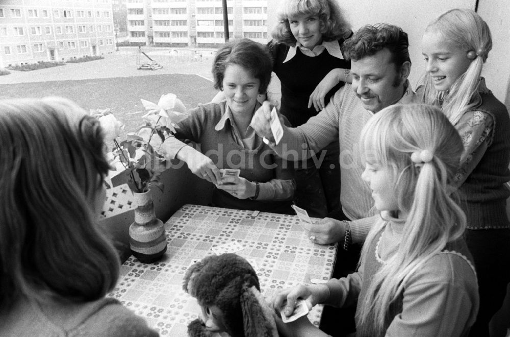 Berlin: Eine junge Familie spielt Karten auf dem Balkon in Berlin