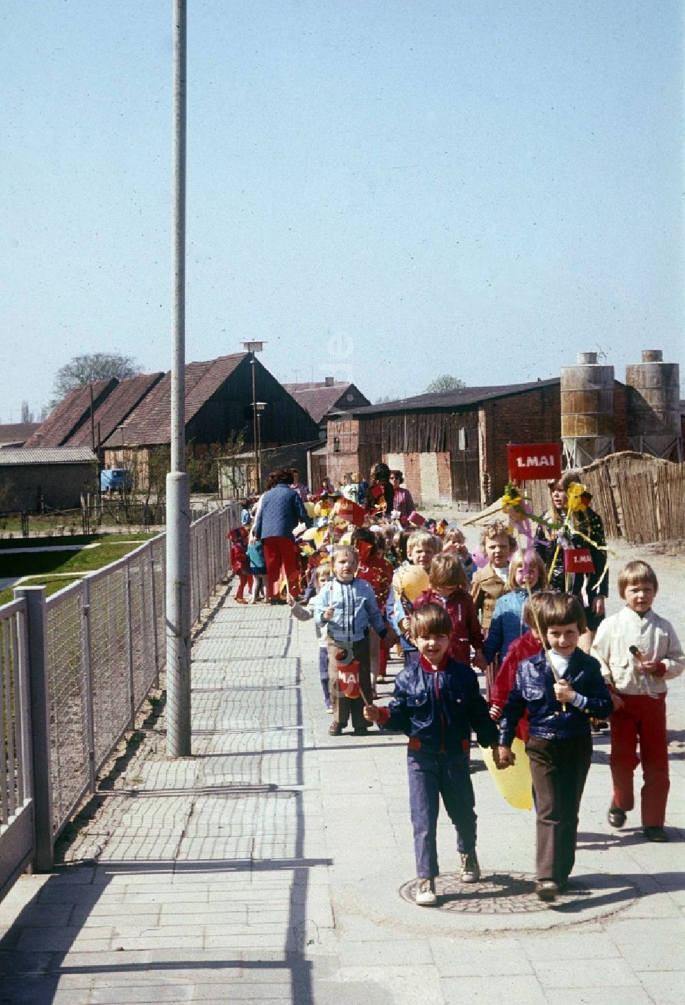 Neustrelitz: Eine Kindergartengruppe, mit Luftballons und Fähnchen, auf dem Weg zur 1. Mai Demonstration in Neustrelitz in Mecklenburg-Vorpommern in der DDR