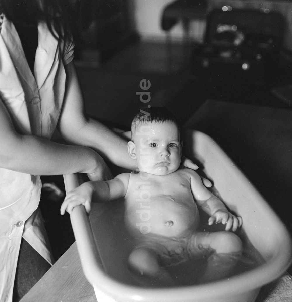 Berlin: Eine Mutter badet ihr Baby in einer Plastik Badewanne in Berlin, der ehemaligen Hauptstadt der DDR, Deutsche Demokratische Republik