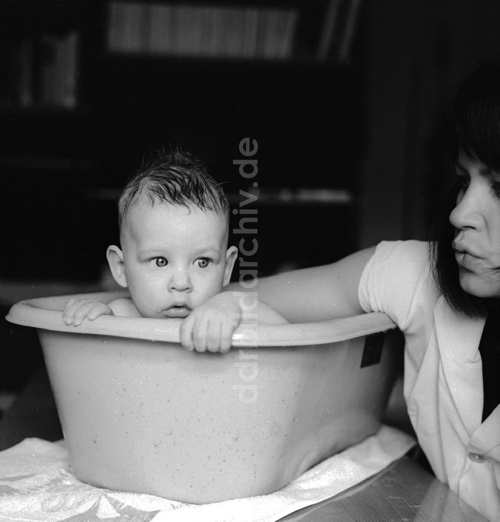 DDR-Bildarchiv: Berlin - Eine Mutter badet ihr Baby in einer Plastik Badewanne in Berlin, der ehemaligen Hauptstadt der DDR, Deutsche Demokratische Republik