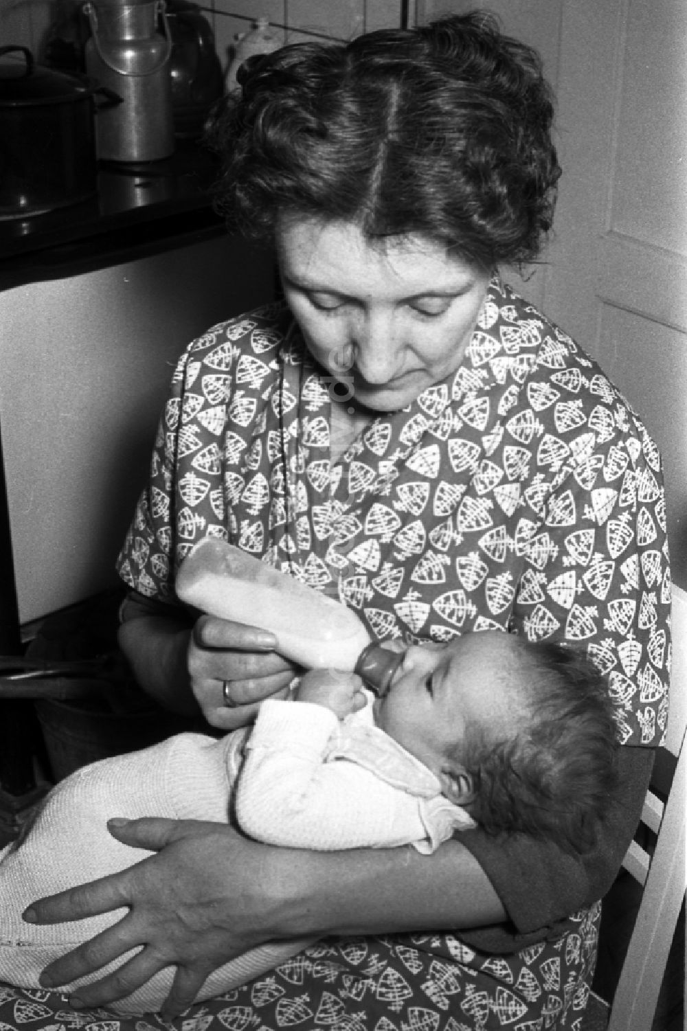 DDR-Bildarchiv: Merseburg - Eine Mutter gibt ihrem Baby die Nuckelflasche in Merseburg in Sachsen-Anhalt in der DDR