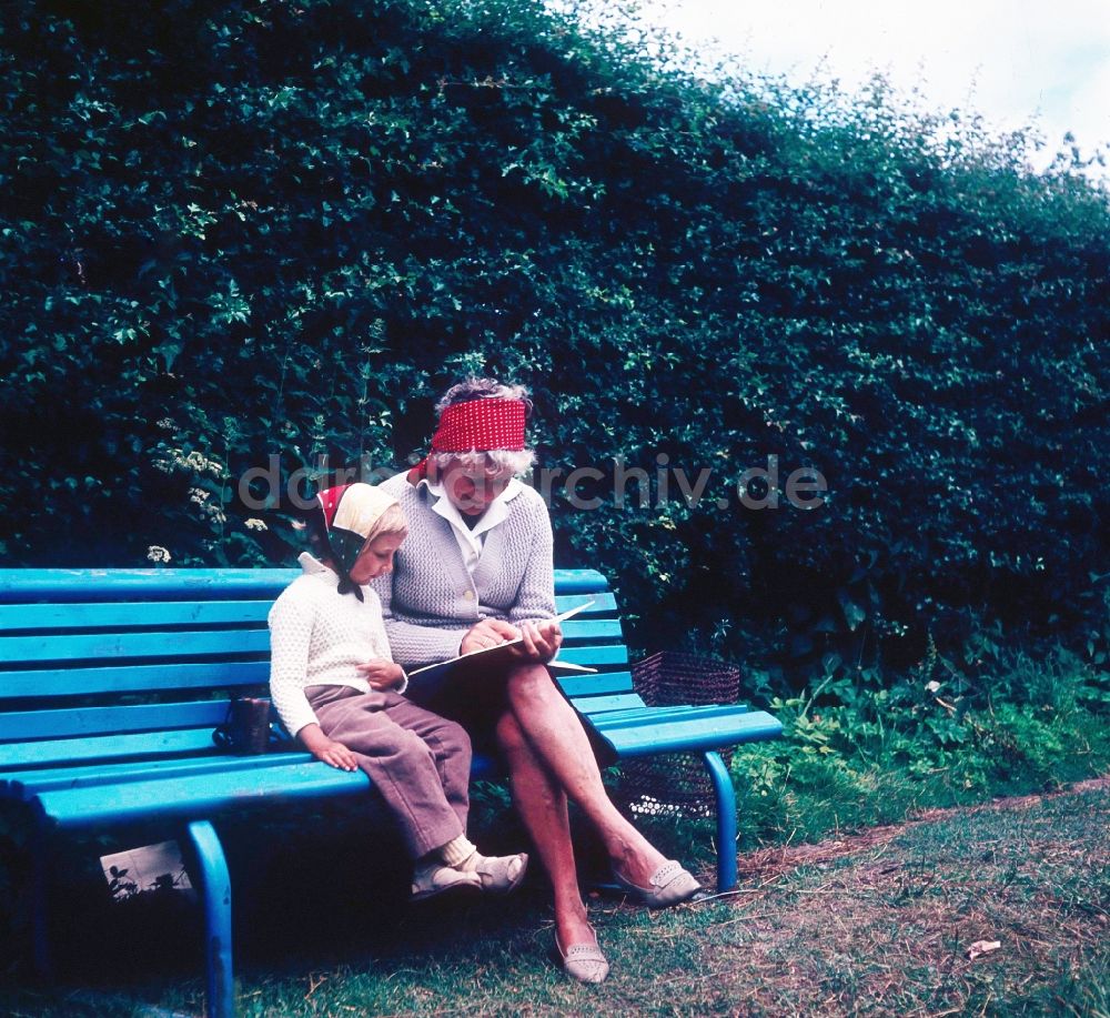 DDR-Bildarchiv: Ahrenshoop - Eine Oma sitzt mit ihrem Enkelkind auf einer Parkbank in Ahrenshoop in Mecklenburg-Vorpommern in der DDR