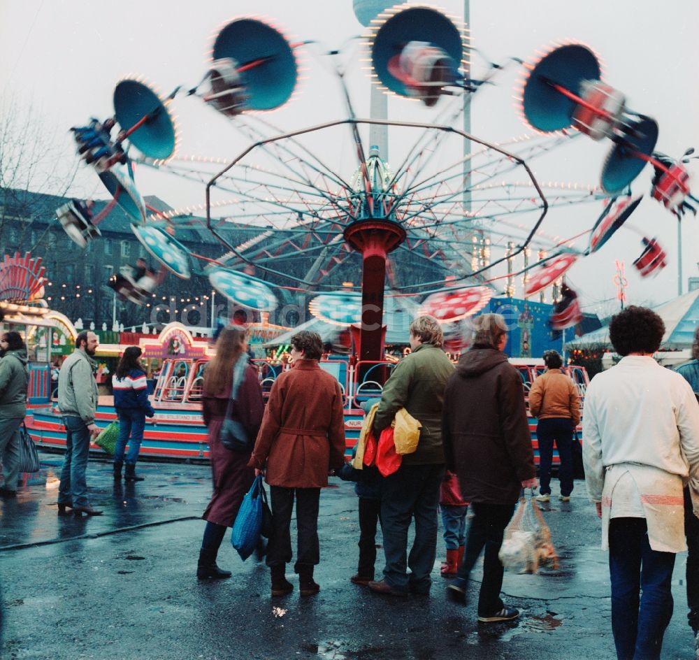 Berlin: Fahrgeschäfte und Besucher auf dem Weihnachtsmarkt in Berlin, der ehemaligen Hauptstadt der DDR, Deutsche Demokratische Republik