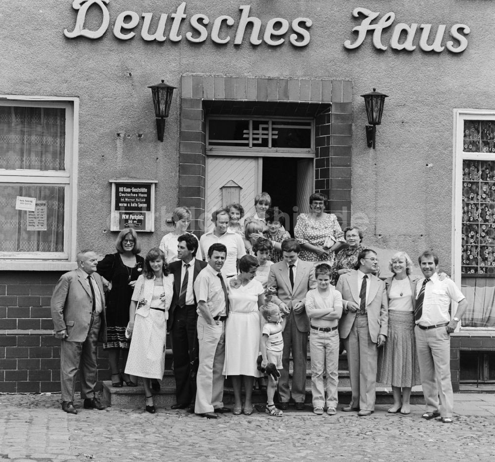 DDR-Fotoarchiv: Berlin - Familienfoto vor der HO Gaststätte Deutsches Haus in Berlin, der ehemaligen Hauptstadt der DDR, Deutsche Demokratische Republik
