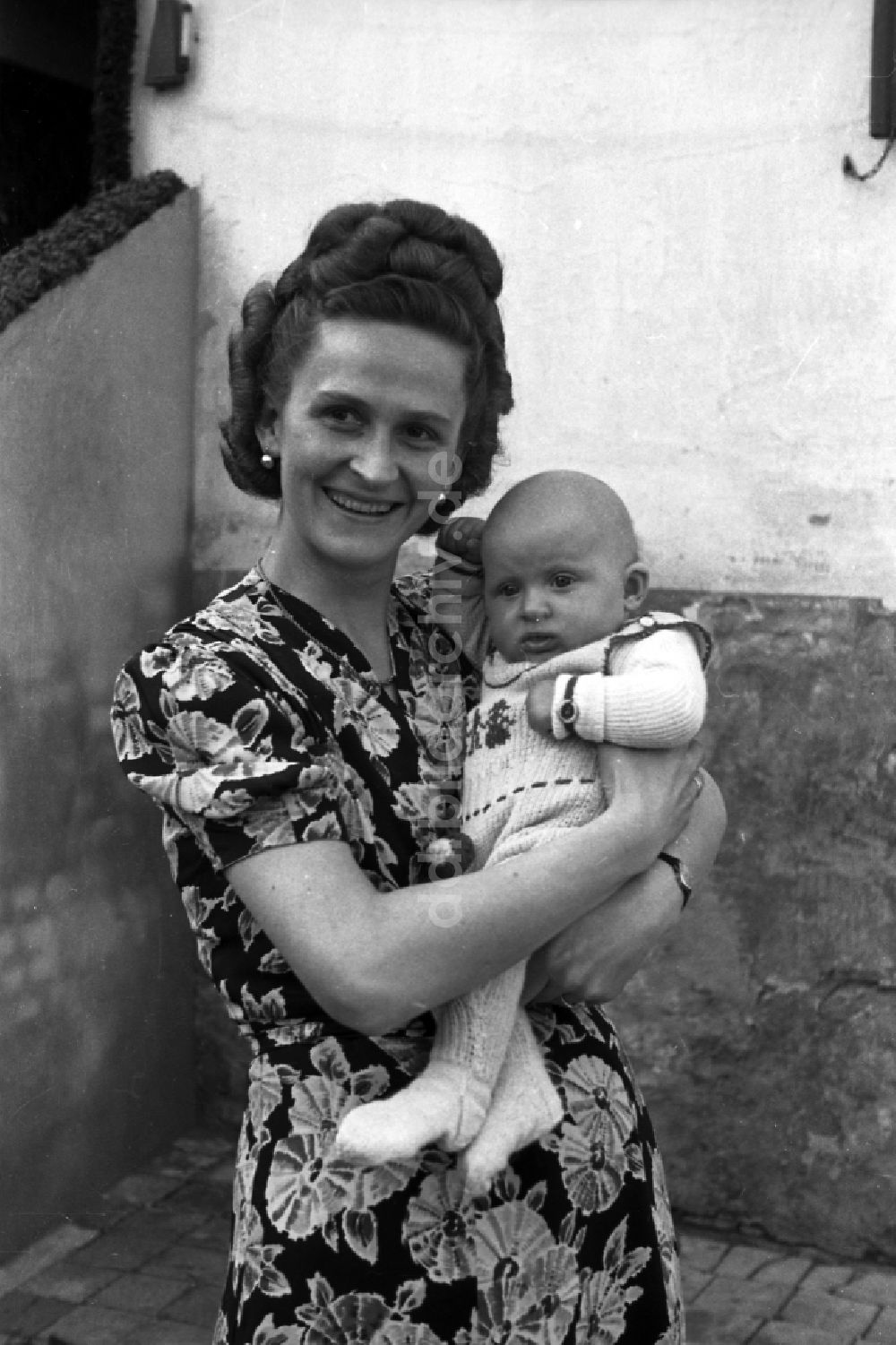 DDR-Bildarchiv: Merseburg - Frau mit Baby auf dem Arm in Merseburg in Sachsen-Anhalt in der DDR