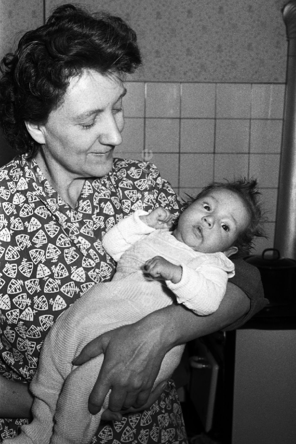 Merseburg: Frau mit Baby auf dem Arm in Merseburg im Bundesland Sachsen-Anhalt auf dem Gebiet der ehemaligen DDR, Deutsche Demokratische Republik