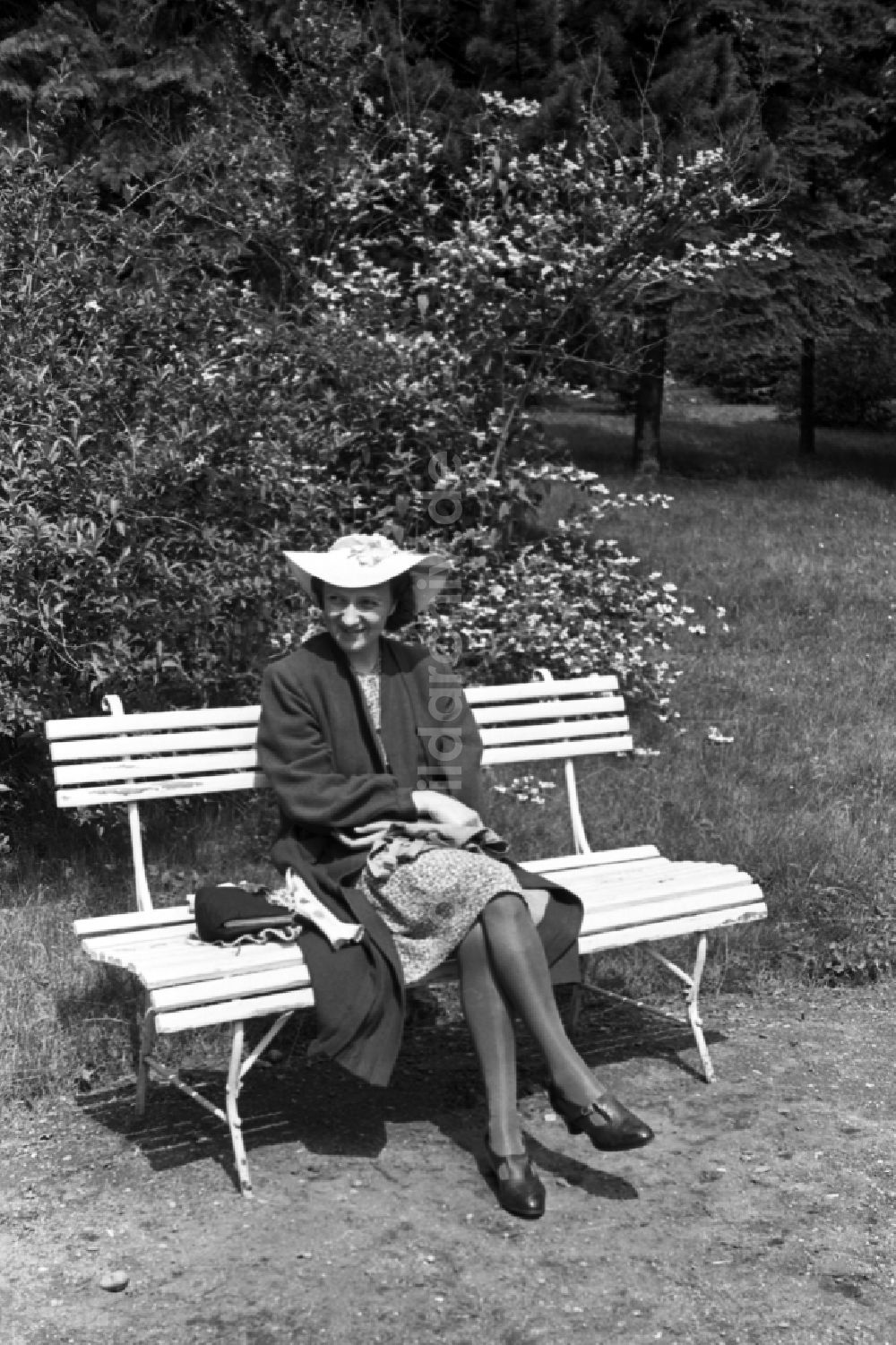 DDR-Fotoarchiv: Bad Dürrenberg - Frau mit Hut auf einer Parkbank in Bad Dürrenberg in Sachsen-Anhalt in Deutschland