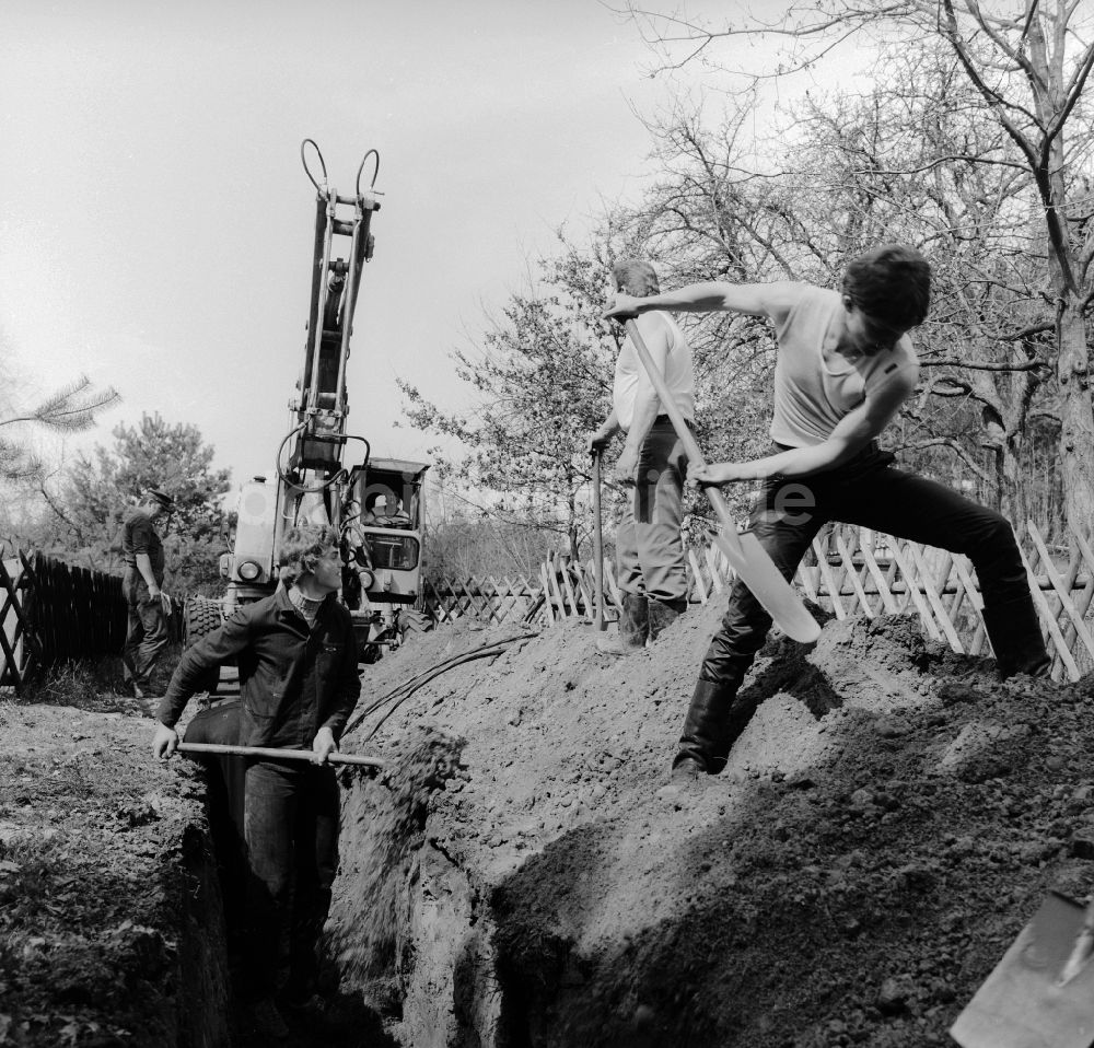 Teupitz: Gartenbesitzer und Anwohner heben gemeinsam einen Kabelgraben aus in Teupitz im Bundesland Brandenburg auf dem Gebiet der ehemaligen DDR, Deutsche Demokratische Republik