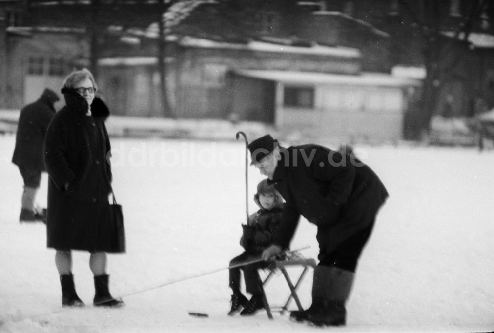 DDR-Fotoarchiv: Berlin - Großeltern mit ihrem Enkel beim Eisangeln auf einem See in Berlin, der ehemaligen Hauptstadt der DDR, Deutsche Demokratische Republik