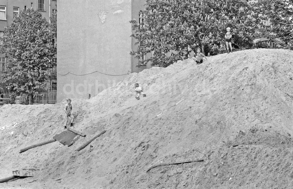 DDR-Bildarchiv: Berlin - Gruppe von Kindern und Jugendlichen auf einem aufgeschütteten Sandberg einer Baustelle in Berlin in der DDR