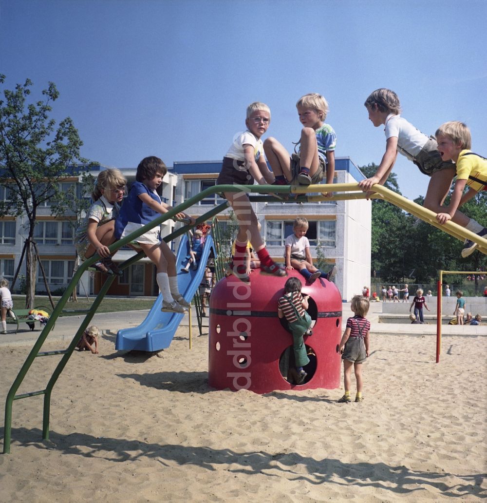 Rostock: Gruppe von Kindern und Jugendlichen auf einem Kletterbogen - Spielplatz in Rostock in Mecklenburg-Vorpommern in der DDR