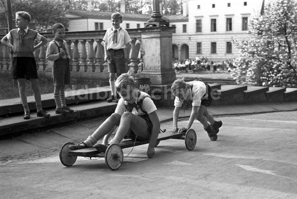 DDR-Bildarchiv: Dresden - Gruppe von Kindern und Jugendlichen mit Pionierkleidung beim Spiel mit selbstgebauten Handwagen vor dem Pionierpalast in Dresden, Deutschland