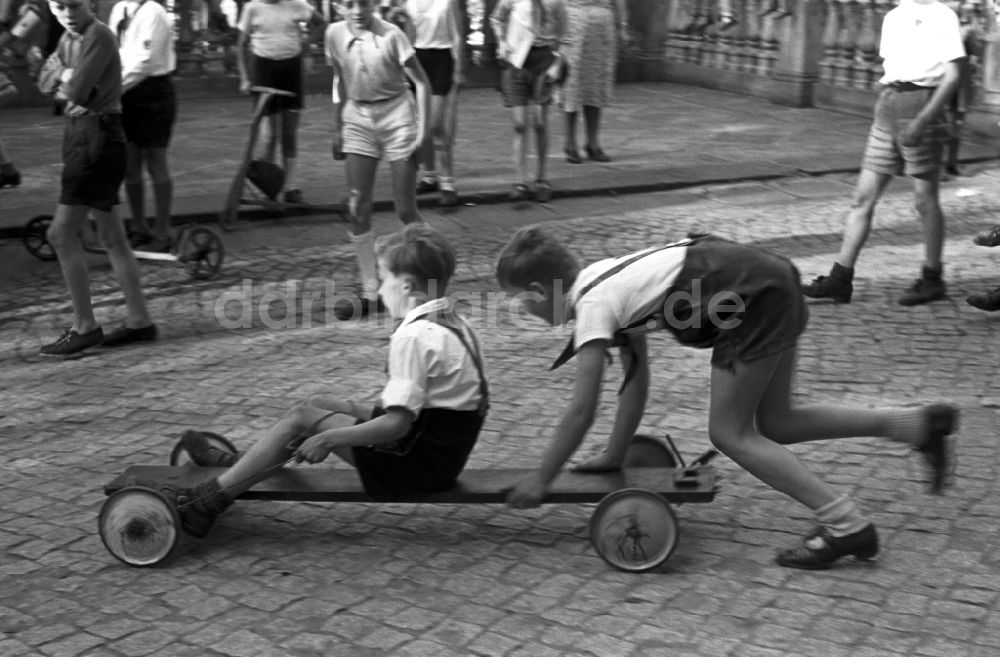 DDR-Fotoarchiv: Dresden - Gruppe von Kindern und Jugendlichen mit Pionierkleidung beim Spiel mit selbstgebauten Handwagen vor dem Pionierpalast in Dresden, Deutschland