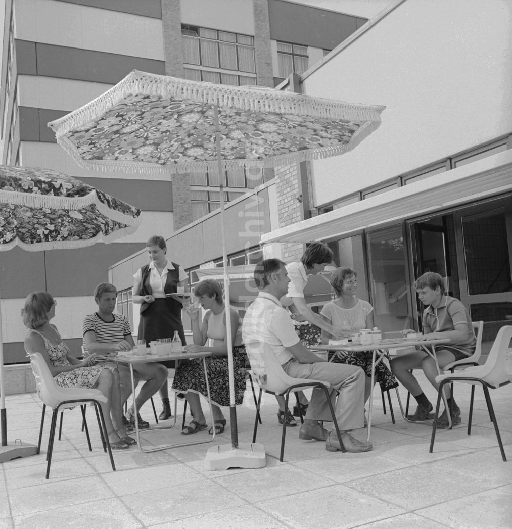 Ückeritz: Gäste trinken Kaffe auf der Aussenterasse unter einem Sommenschirm in Ückeritz in Mecklenburg-Vorpommern in der DDR