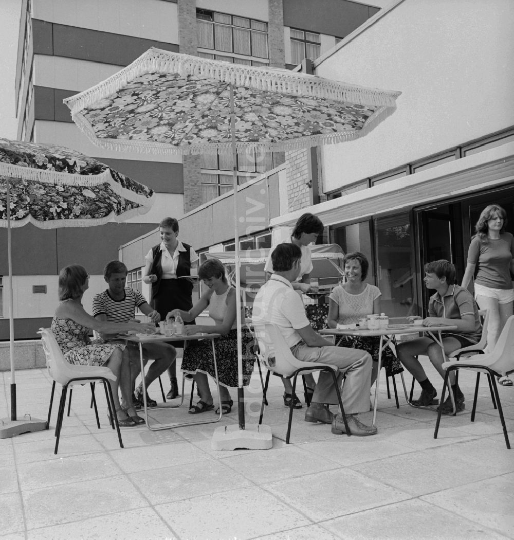 DDR-Bildarchiv: Ückeritz - Gäste trinken Kaffe auf der Aussenterasse unter einem Sommenschirm in Ückeritz in Mecklenburg-Vorpommern in der DDR