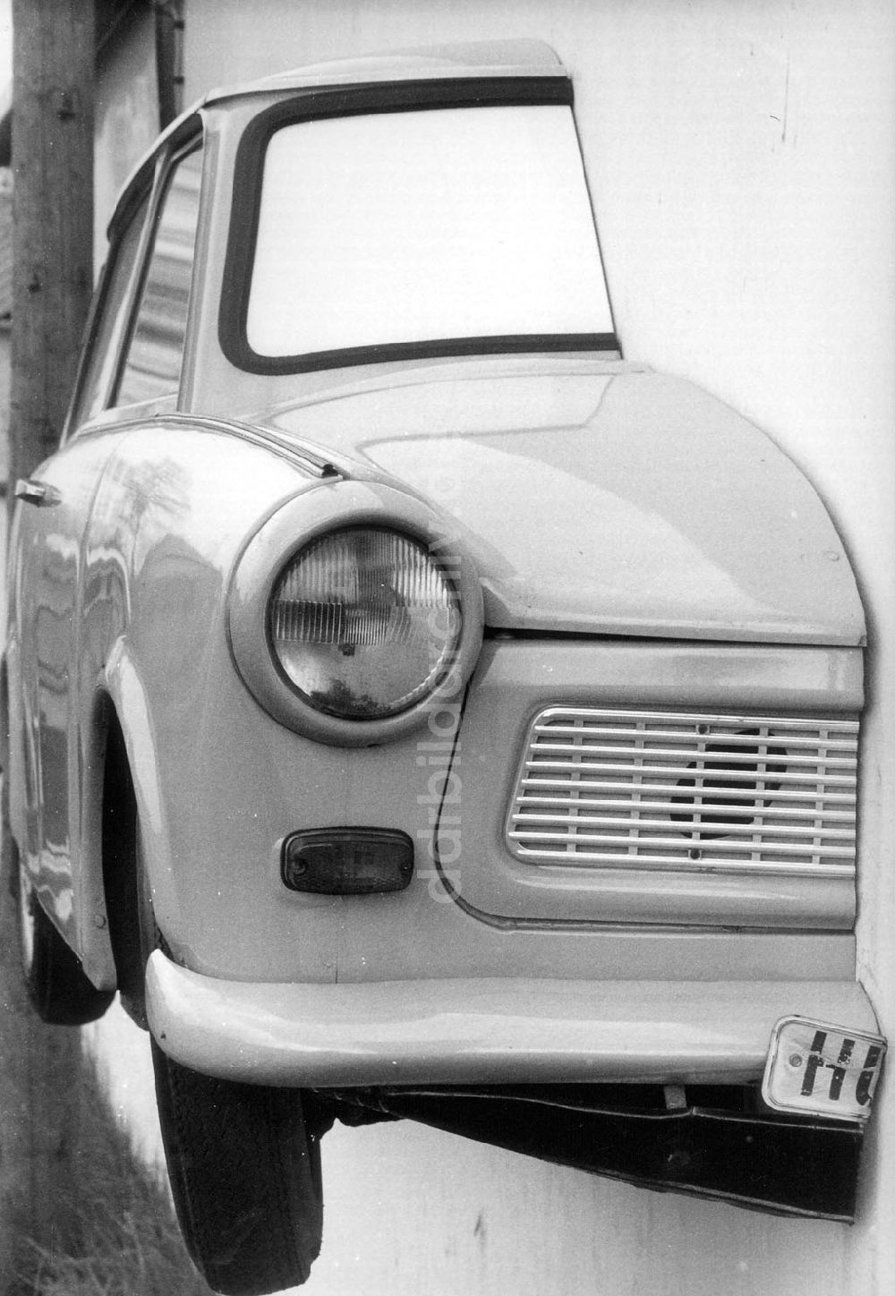 DDR-Bildarchiv: Loburg - Halbierter Trabant eines Autohändlers an der Mauer seines Betriebsgeländes in Loburg (Sachsen-Anhalt) 07.05.1992