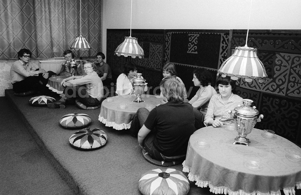 DDR-Bildarchiv: Berlin - Jugendliche sitzen auf dem Boden in der Teestube im Jugendtouristenhotel Egon Schultz am Tierpark in Berlin, der ehemaligen Hauptstadt der DDR, Deutsche Demokratische Republik