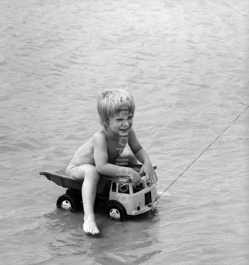 DDR-Fotoarchiv: Teupitz - Junge auf einem Plastik LKW im Wasser am Teupitzer See in Teupitz in Brandenburg in der DDR