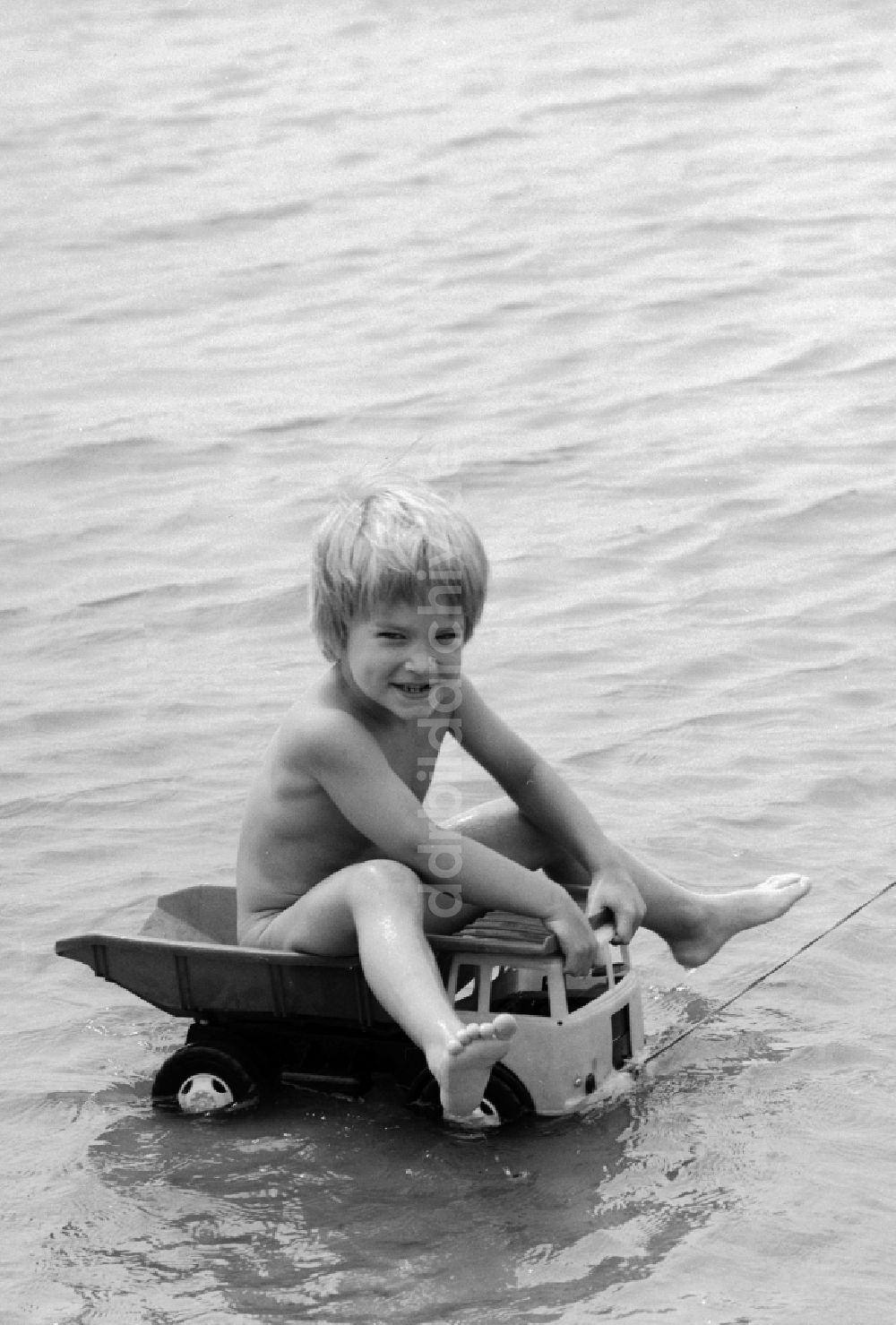 Teupitz: Junge auf einem Plastik LKW im Wasser am Teupitzer See in Teupitz in Brandenburg in der DDR