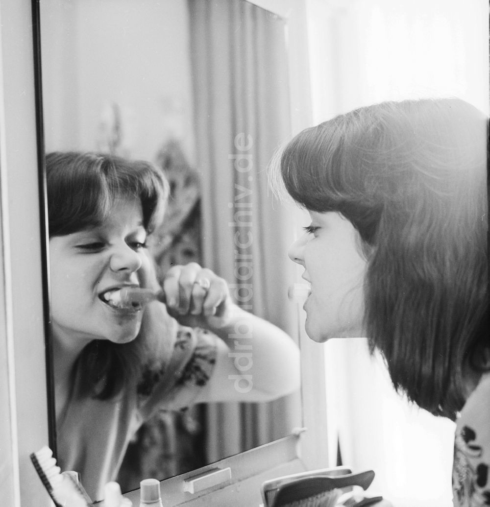 Berlin: Junge Frau beim Zähneputzen vor dem Spiegel in Berlin