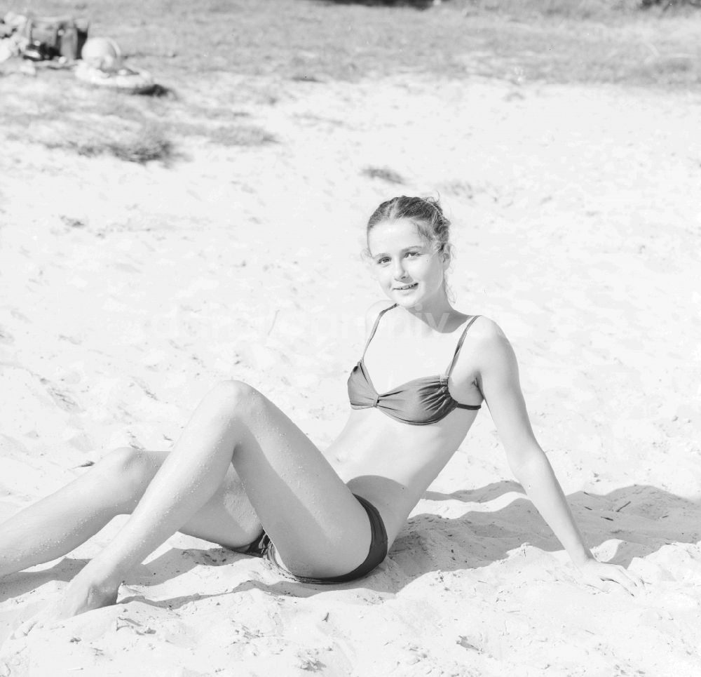 Grünheide (Mark): Junge Frau bekleidet mit einem Bikini an einem Sandstrand in Grünheide (Mark) im Bundesland Brandenburg auf dem Gebiet der ehemaligen DDR, Deutsche Demokratische Republik