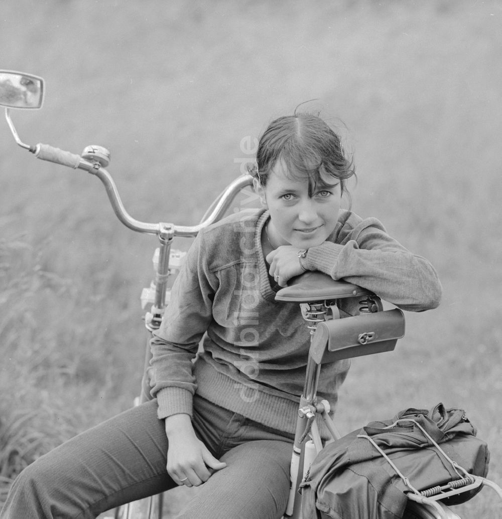 DDR-Fotoarchiv: Hohen Neuendorf - Junge Frau sitzt auf einem Fahrrad in Hohen Neuendorf im heutigen Bundesland Brandenburg