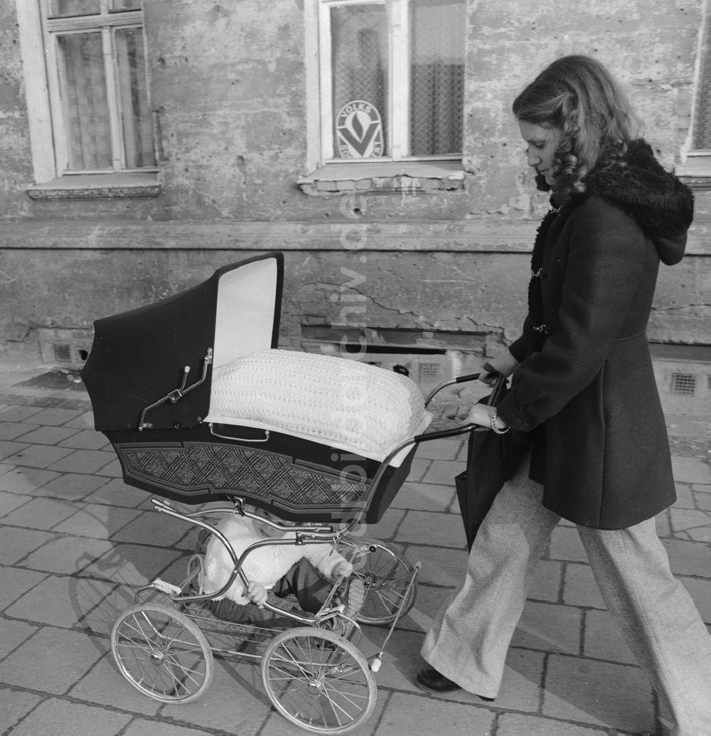 DDR-Fotoarchiv: Berlin - Junge Mutter mit Kinderwagen beim Spaziergang in Berlin